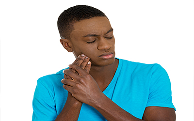 A man holding the side of his jaw in pain