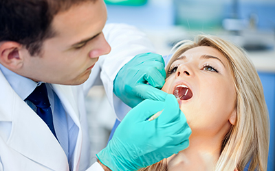 A girl having her teeth worked on by a dentist
