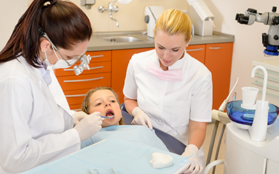 Dental assistant with dentist and child