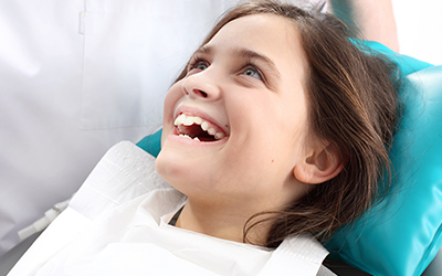young girl sitting in dental chair waiting for dental exam