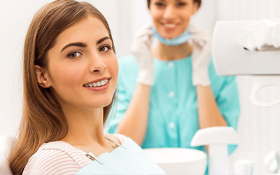 Young lady in dental chair with staff in background