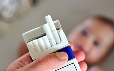 Pack of cigarettes with a young child in the background